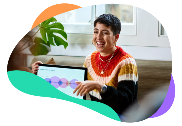 Young woman smiling while presenting a product launch roadmap on her laptop